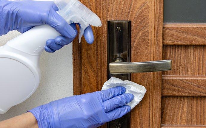 an up close image of a person disinfecting a door