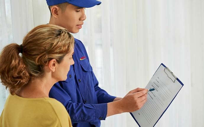 technician and homeowner looking at paperwork