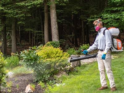 Prevent Ticks & Mosquitoes Today With Pine State Pest tick control specialist treating bushes for ticks in auburn maine