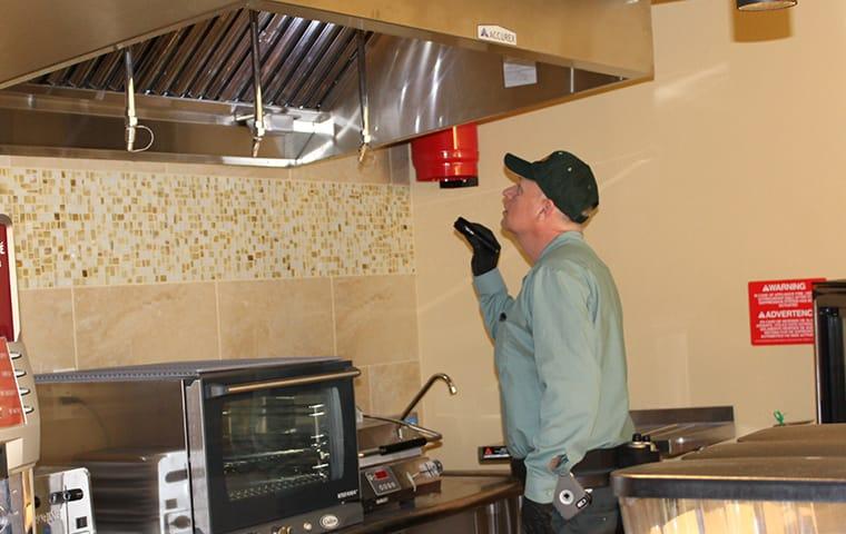 a bill clark pest control technician inspecting a commercial kitchen in buna texas