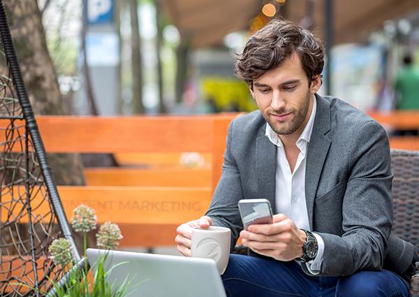 Learn About Content Marketing And How It Can Help Your Business a man sitting on an outdoor bench looking at his cell phone
