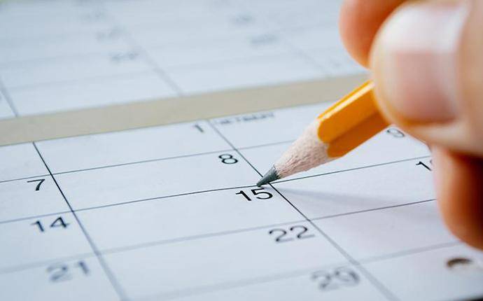 person marking date on calendar