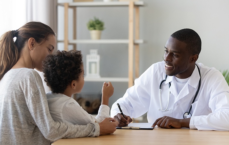 a doctor meeting with a child and mother inside a medical facility