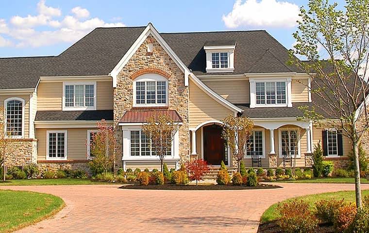 a three story house with a brick driveway