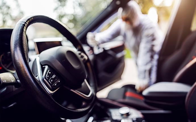 a technician disinfecting the inside of a car