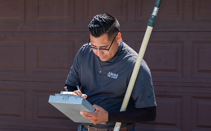 pest control technician inspecting exterior