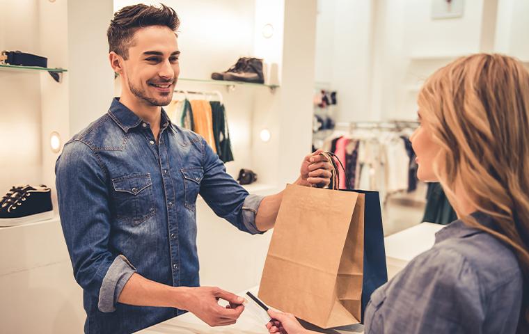 sales associate handing bag to customer