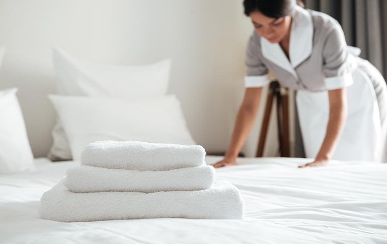 cleaning lady making the hotel bed