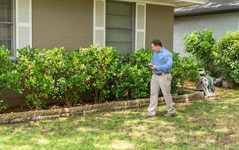 a technician inspecting the outside of a house in modesto california