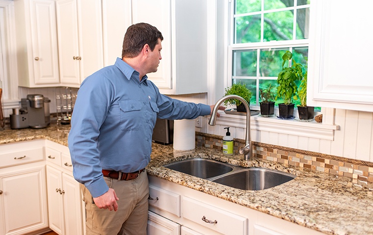 a pest technician inspecting the kitchen of a home in modesto california