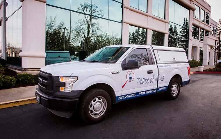 street view of a pest control truck in front of a large commercial building in modesto california