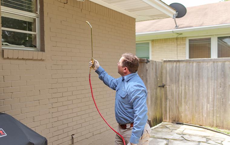 technician treating exterior of a home