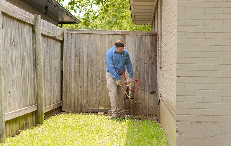 a pest technician performing an exterior treatment at a home in modesto california