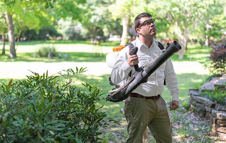 a pest control service technician arriving to perform mosquito reduction treatments on the exterior of a home in charlotte north carolina