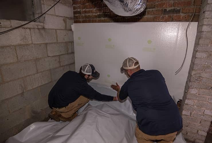 What Are The Benefits Of Moisture Control two men installing moisture control in a south carolina home