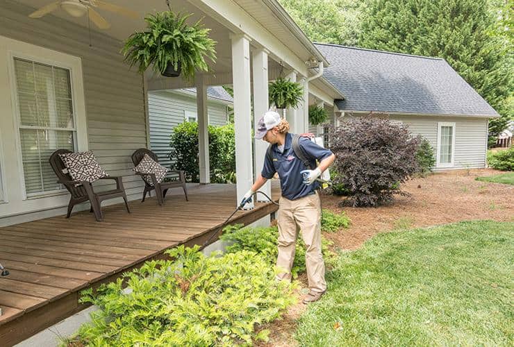 Call Spencer Today About Home Pest Control technician spraying shrubs