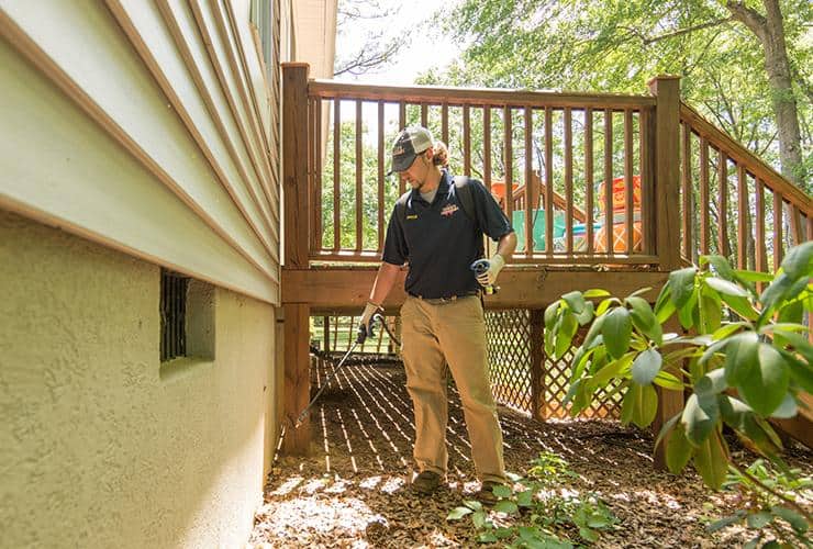 Perimeter Pest Control Treatment For Homes technician creating a barrier of protection so bugs can't sneak in