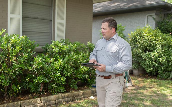 pest-pro technician performing an exterior rodent inspection