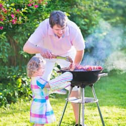 father helping daughter barbecue