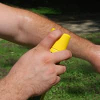 man using bug spray with deet