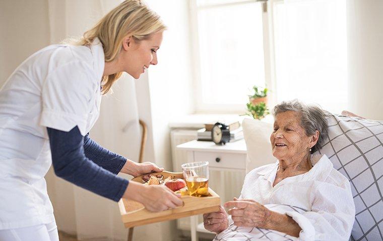 a healthcare worker assisting an elderly patient in a retirement facility