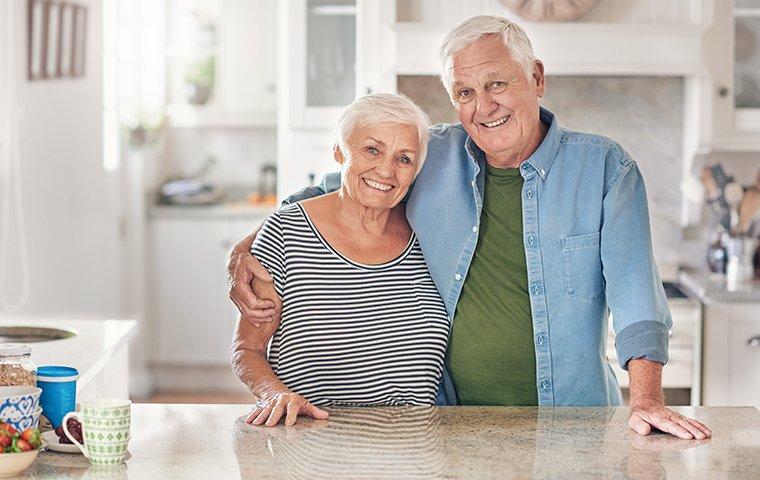 elderly couple standing in their kitchen