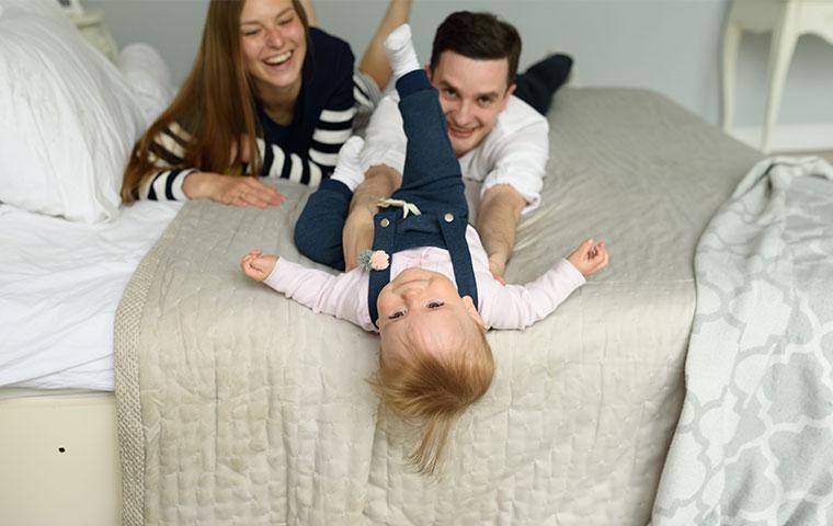 family laying on a bed