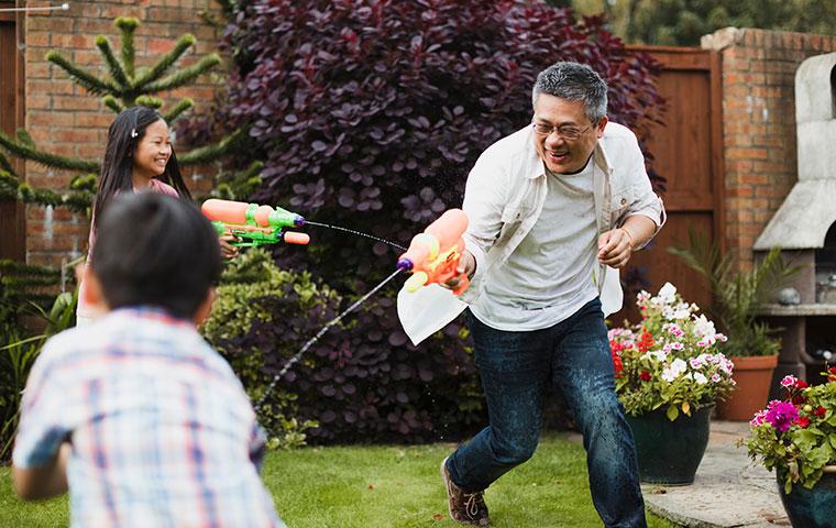 father and kids shooting squirt guns