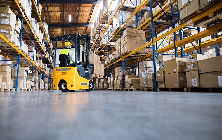 a worker driving a forklift in a warehouse