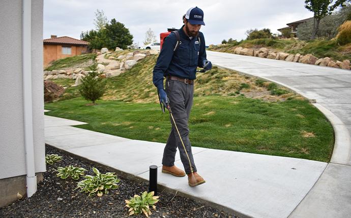 pest control technician inspecting exterior in meridian idaho