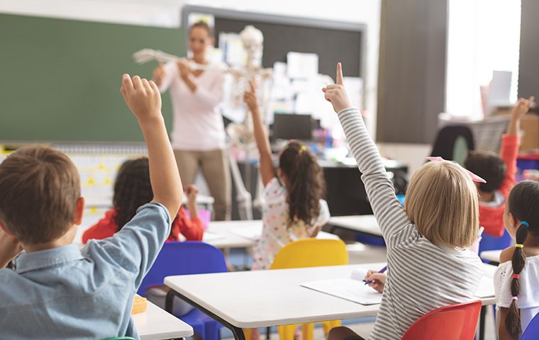 a classroom full of young children that are listening to their teacher