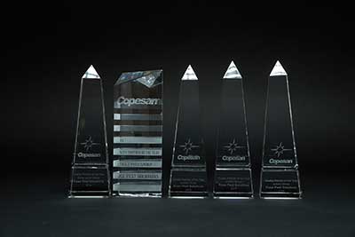 5 consecutive copesan award trophies on black background