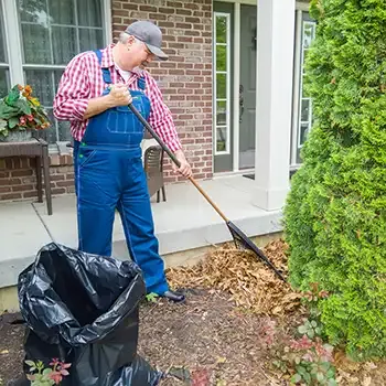 man clearing mulch from building