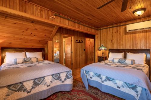Two beds in a wood paneled room