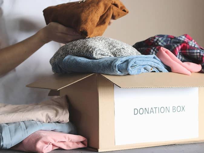 long island homeowners preparing a box of clothes to donate