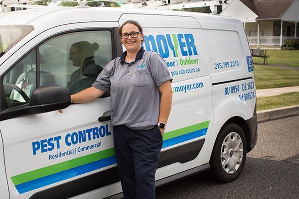 moyer pest control specialist standing by a branded pest control vehicle