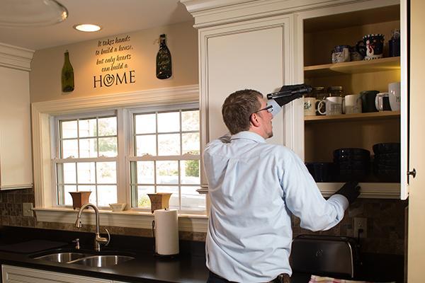 a pest expert inspecting a kitchen in a home in swedeland pennsylvania
