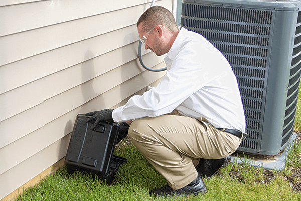 a pest technician checking a rodent trap outside of a roanoke va home