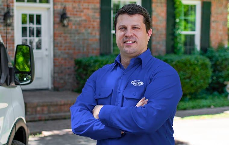 a jury pest services technician standing outside of a home in aiken south carolina