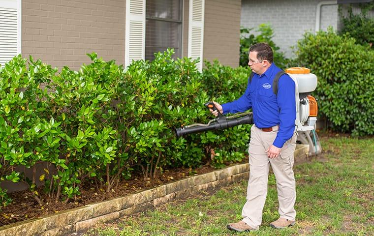 a service technician performing an exterior treatment at a home in aiken south carolina