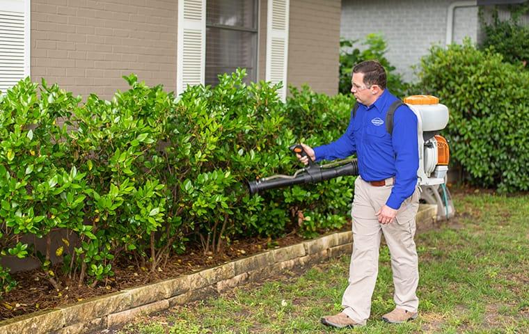 Our Specialty Services Provide More Protection For Homes a service technician performing an exterior treatment at a home in aiken south carolina