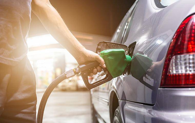 man filling up car with gas