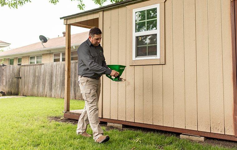 a pest expert treating for termites outside of a home in hendersonville north carolina