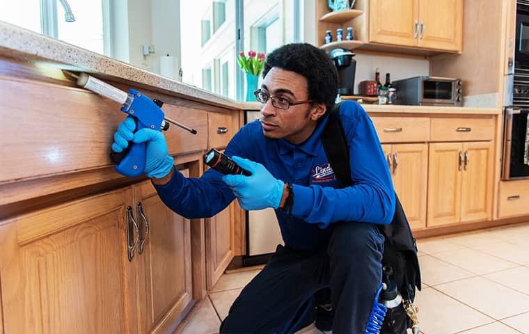 a professional Pest control technician treating a jacksonville home against cockroaches