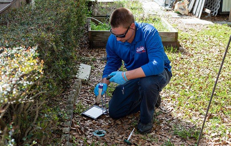 pest control tech inspecting for termites outside a bryceville florida home