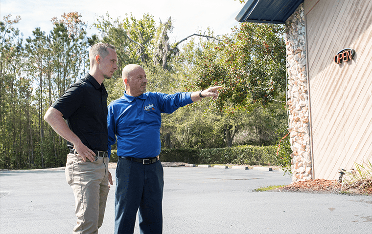 a service technician meeting with a customer outside a neptune beach commercial building