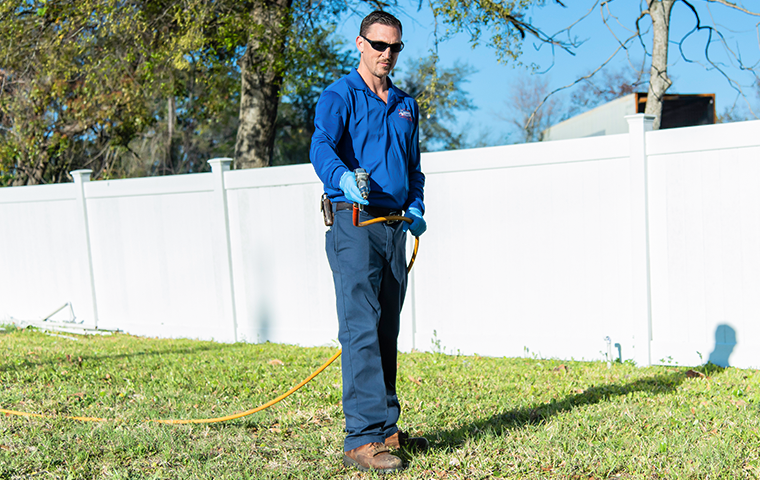 a pest technician treating the outside of a northern florida home for fleas