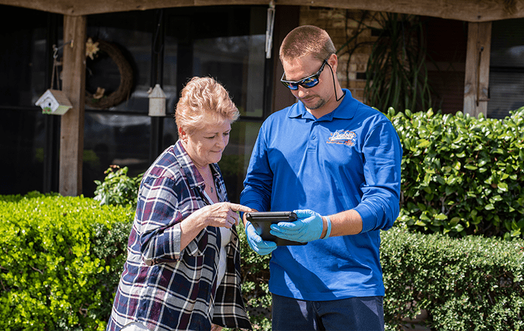 a pest technician going over information with a neptune beach resident