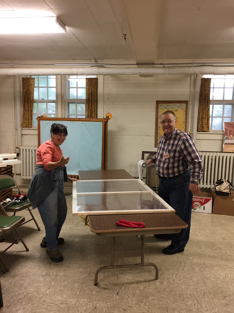 Volunteers Wendy and Sandy apply the final heat to 'shrink' the plastic on a recently built panel.