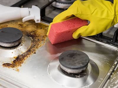 homeowner cleaning stove top